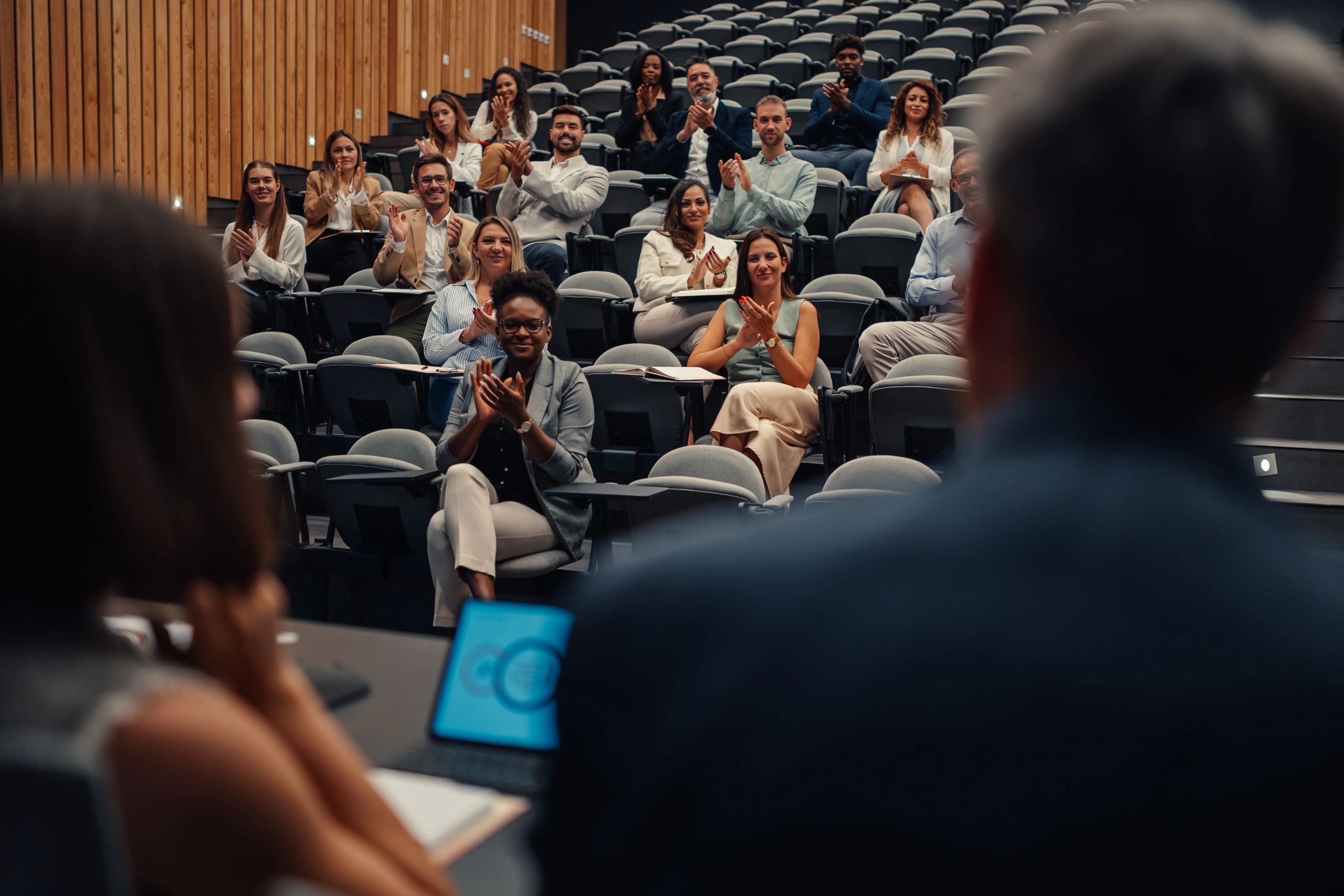 Conference attendees applauding during an educational session